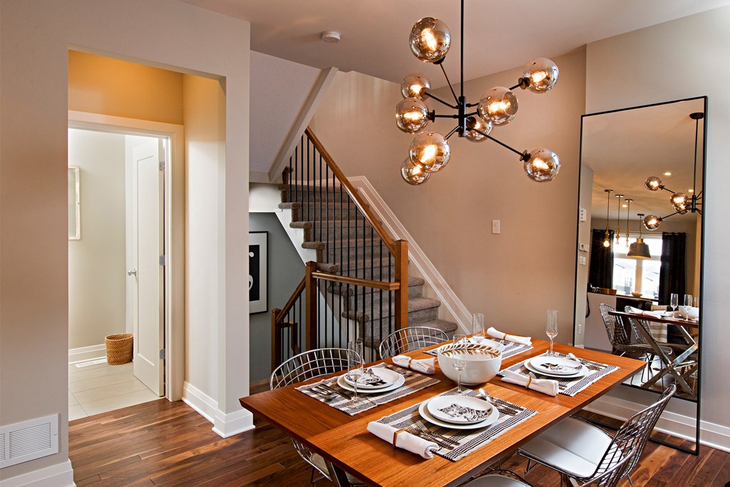 a dining room with a wooden table and chairs under a chandelier