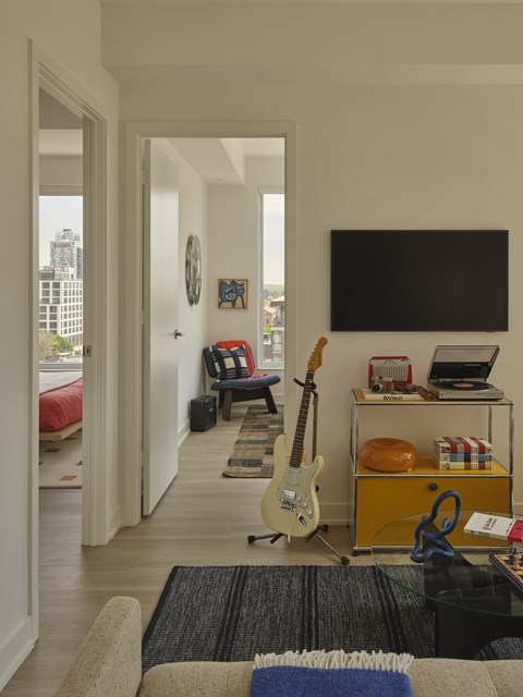 A living room with a guitar on the floor.