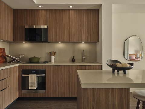A modern kitchen with wooden cabinets and a black oven.