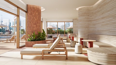 A modern outdoor lounge area with wooden furniture and a view of the city.