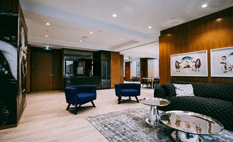 A living room with a black couch and a blue chair.