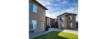 an apartment building with a sidewalk and grass