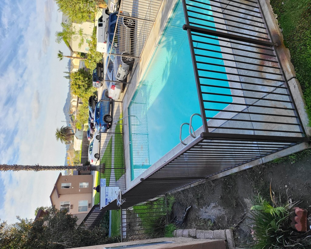 an overhead view of a pool with blue water and black stairs