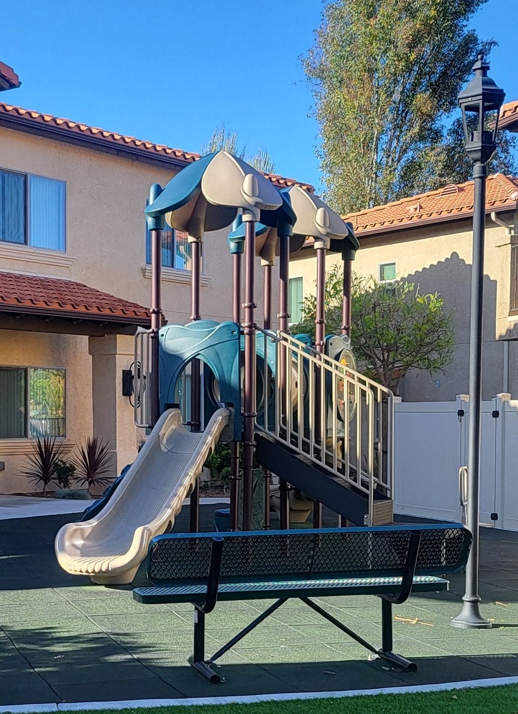 a playground in front of a house with a slide