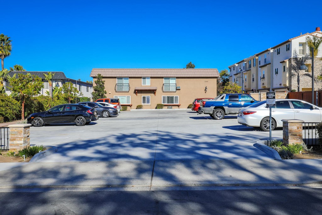 a parking lot with cars in front of an apartment building
