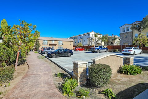 a parking lot with cars parked in front of apartments