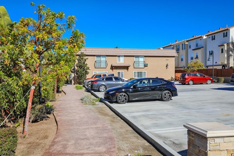 a parking lot with cars parked in front of an apartment building