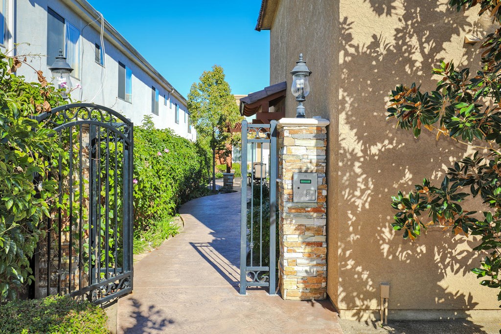 a wrought iron gate in front of a house with a walkway