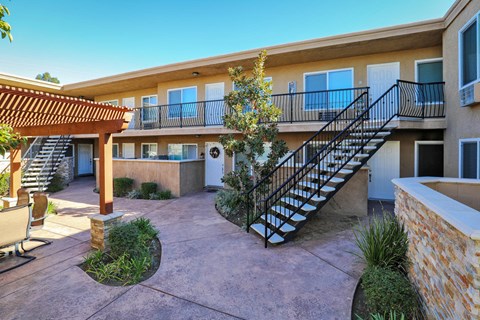 a building with a staircase and a courtyard in front of it