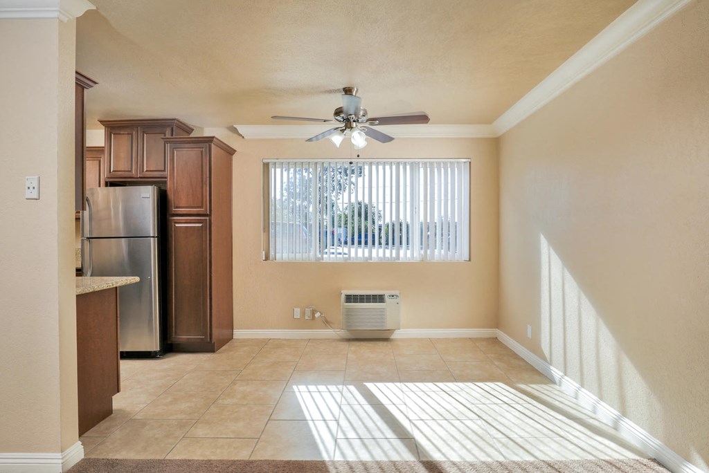 an empty kitchen with a ceiling fan and a window