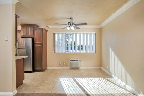 an empty kitchen with a ceiling fan and a window