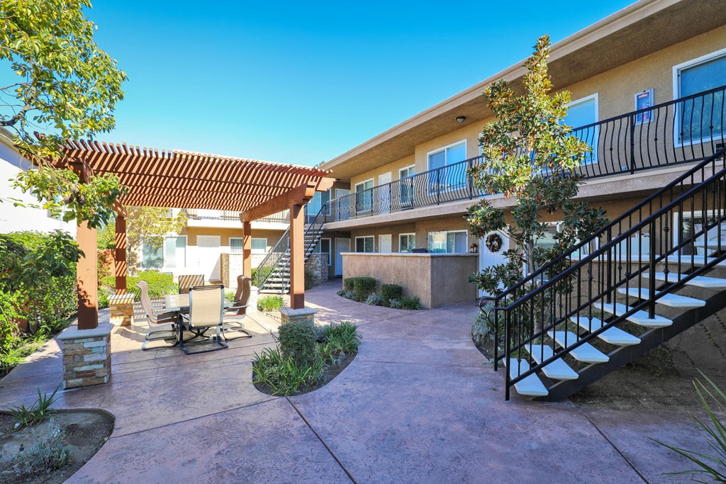 a building with a staircase and a patio with chairs