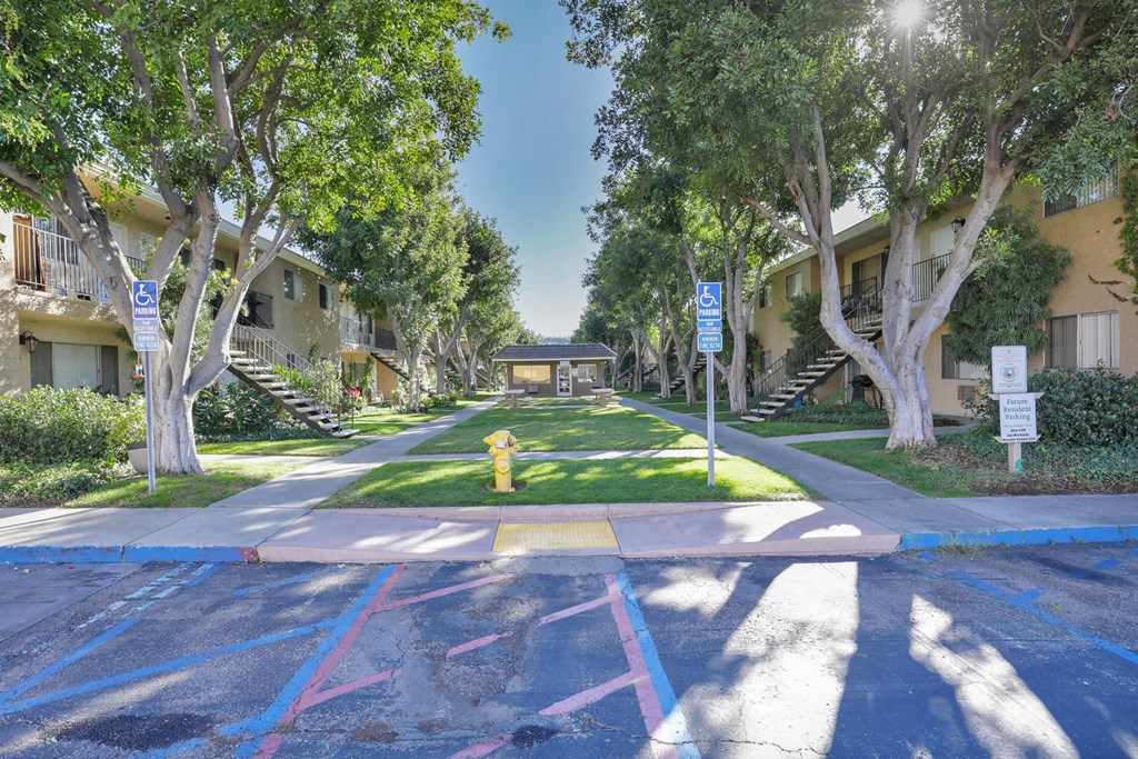 a street with houses and trees and a yellow fire hydrant