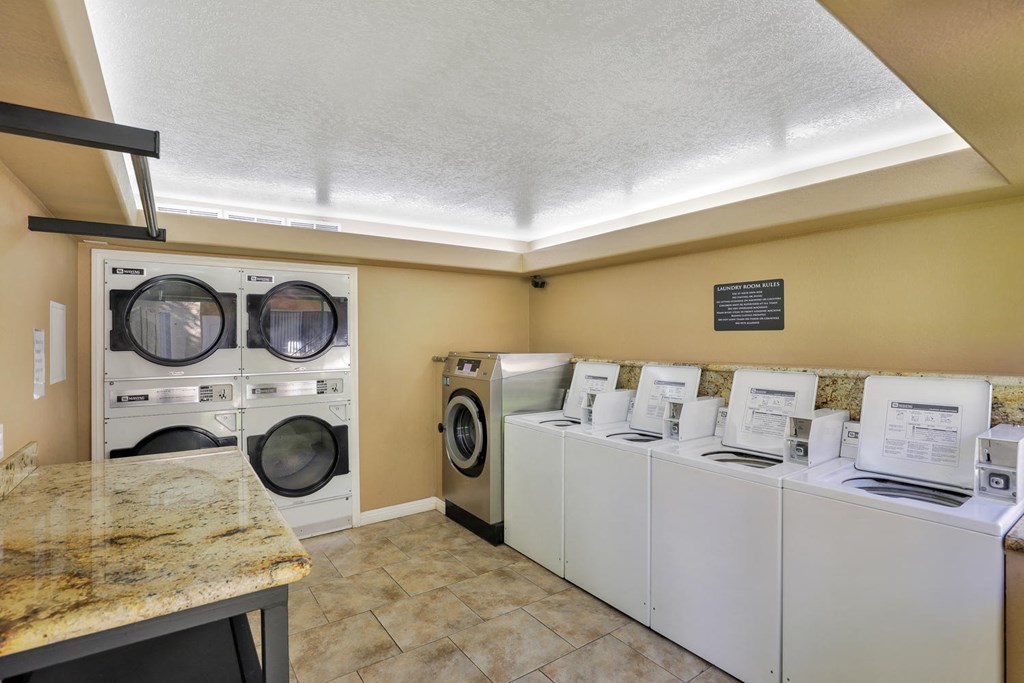 a laundry room with washers and dryers and a counter with a counter top