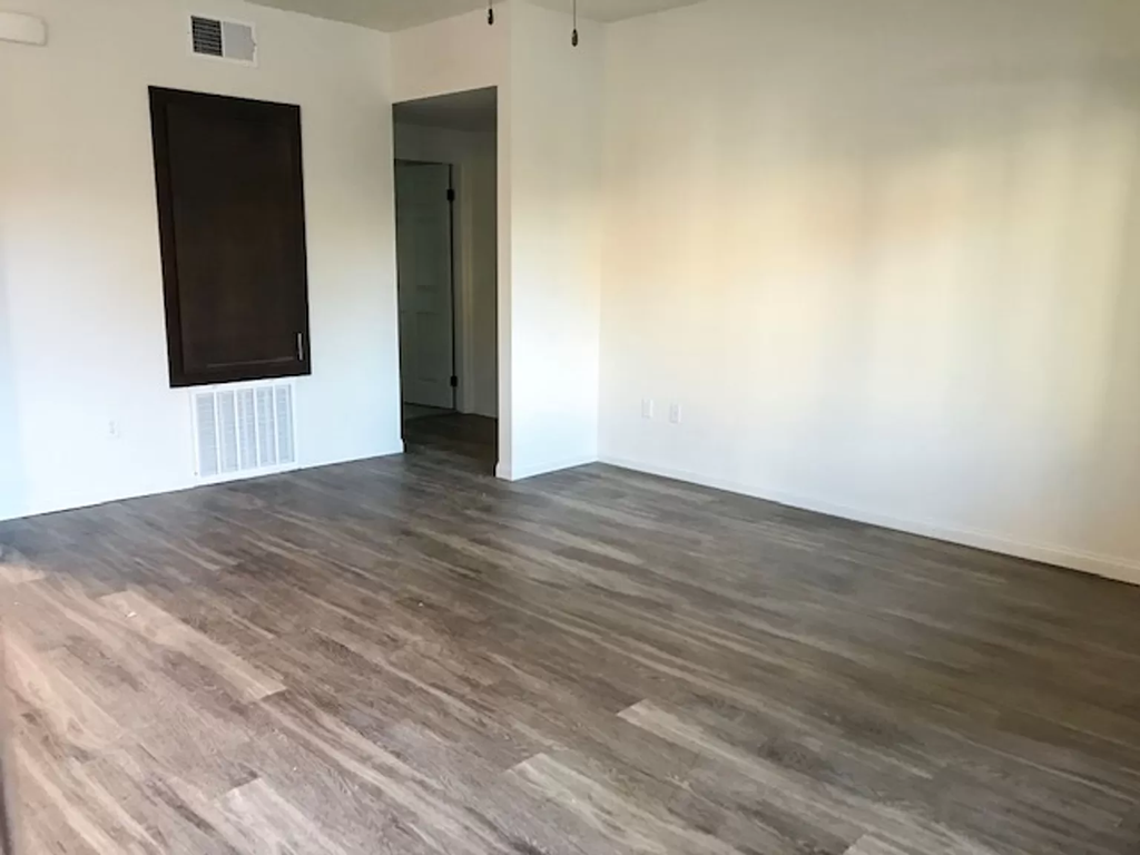 an empty living room with white walls and wood floors