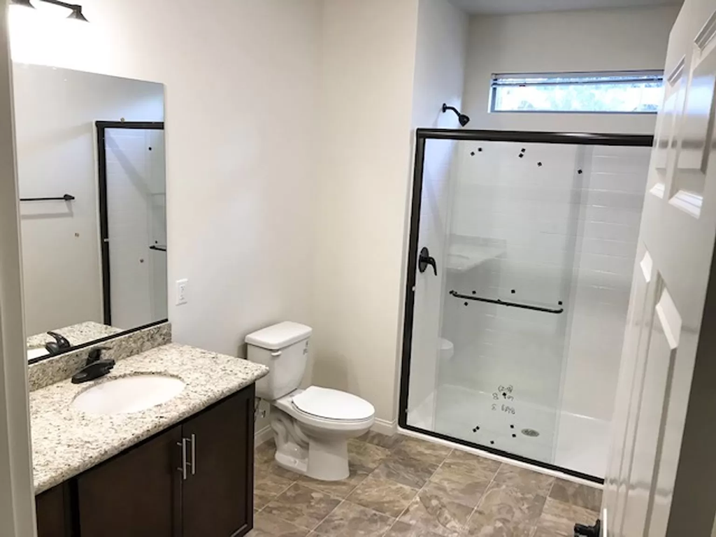 a bathroom with a toilet and a shower
