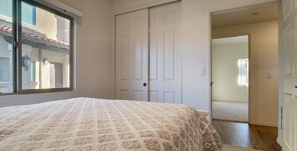 a bedroom with a bed and a window and a closet