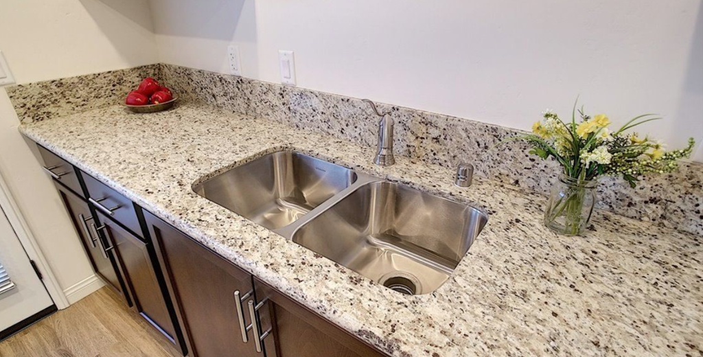 a kitchen with a stainless steel sink and granite counter top