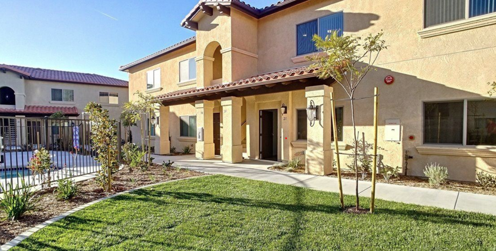 a house with a yard and a sidewalk in front of it