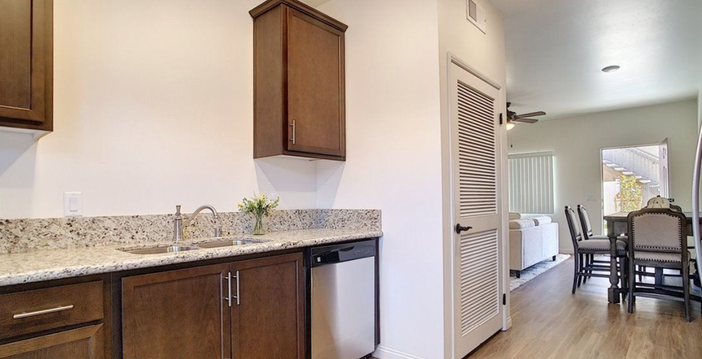 a kitchen with a sink and a door to a dining room