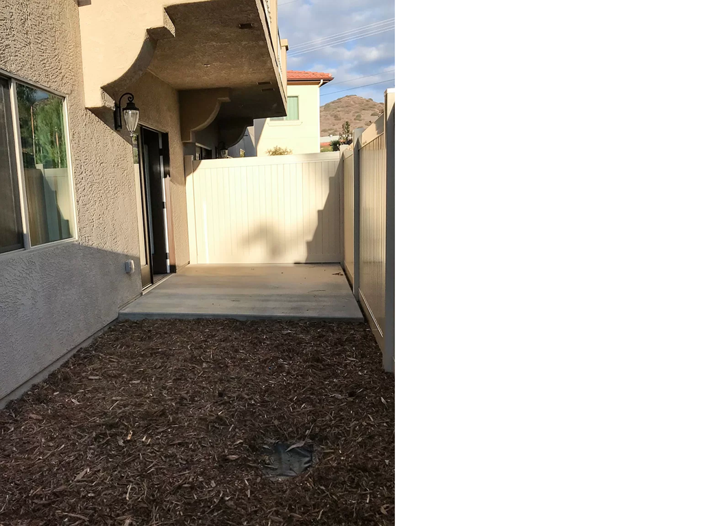 a walkway leading up to a house with a fence