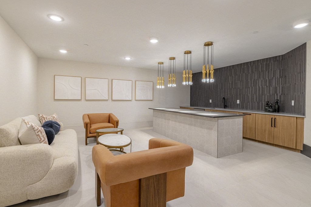 a living room with a kitchen and a couch and chairs