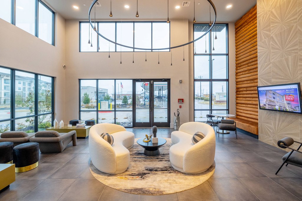 the lobby of a hotel with couches and a fireplace