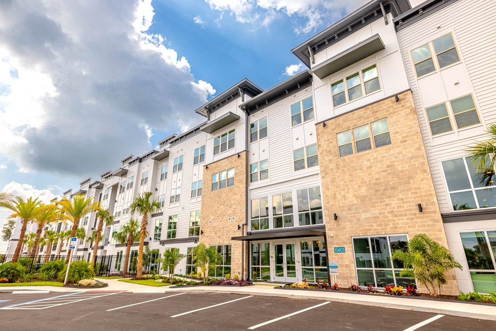 a large apartment building with palm trees in front of it
