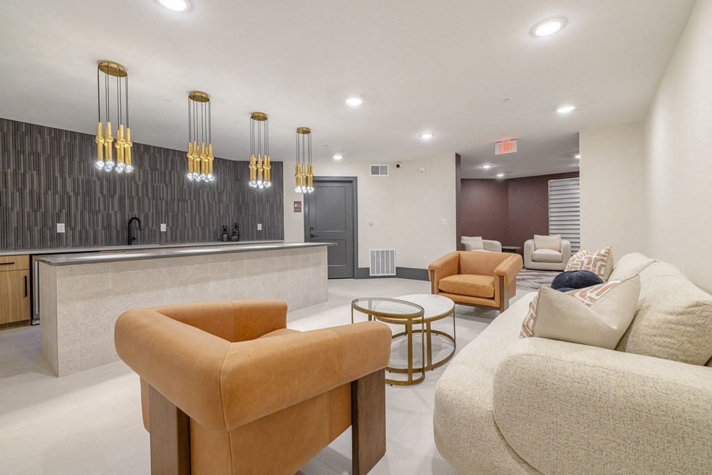 a living room with couches and chairs and a kitchen