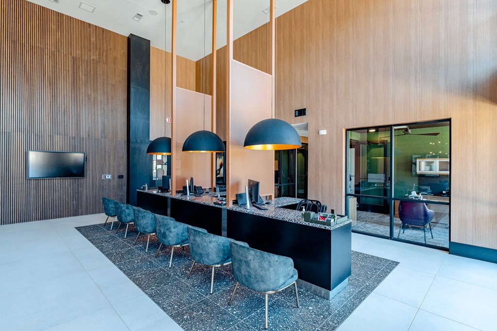 a kitchen with a long counter and chairs in a lobby