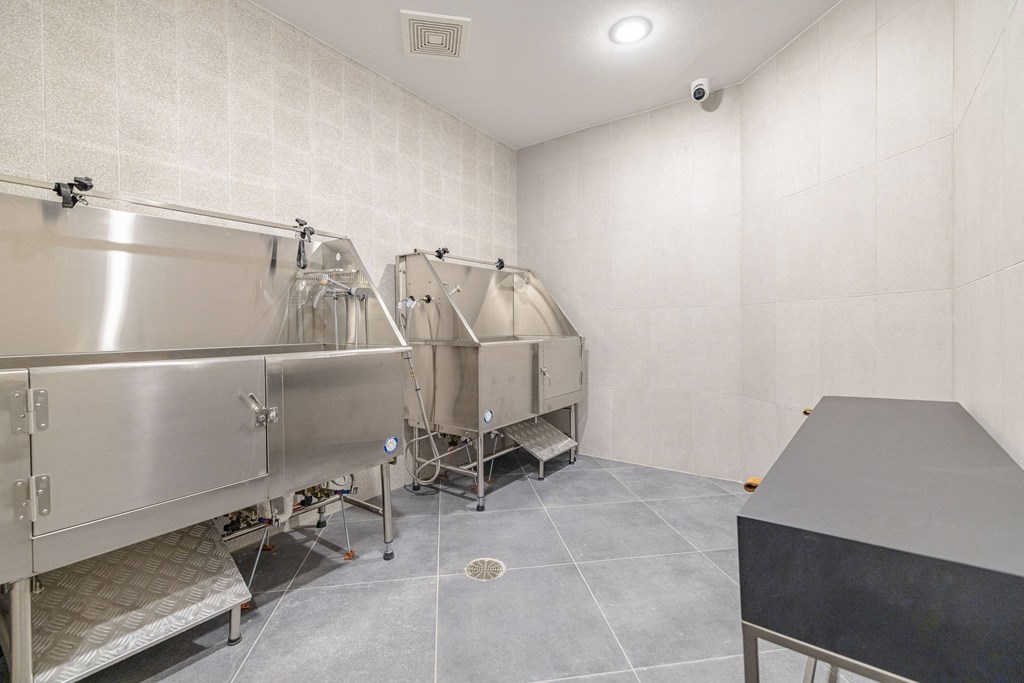 a brewery room with two stainless steel fermentation tanks and a table