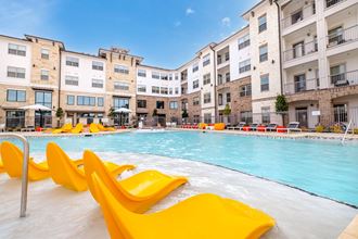 our apartments have a large swimming pool with yellow chairs