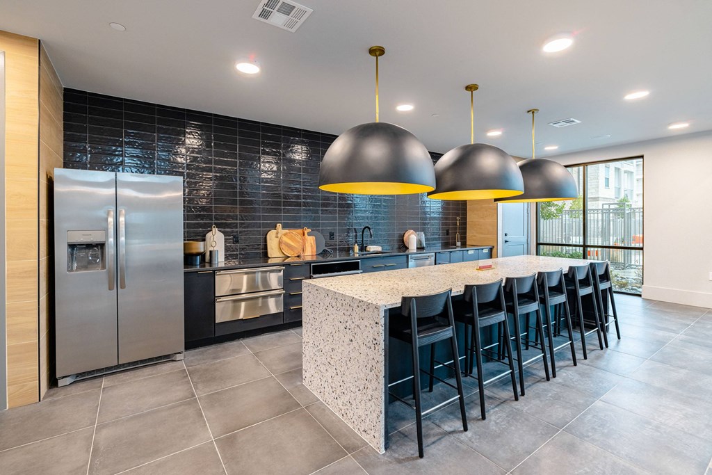 a large kitchen with a long island with blue chairs