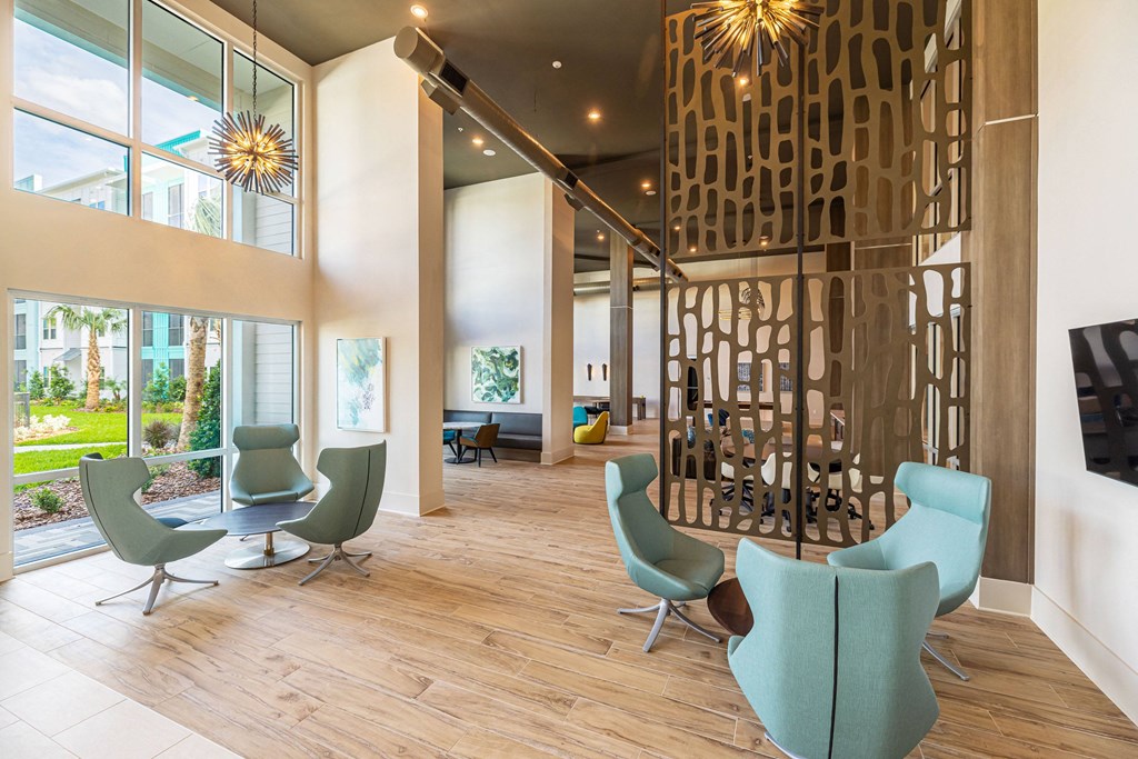 a lobby with chairs and a television and a large window
