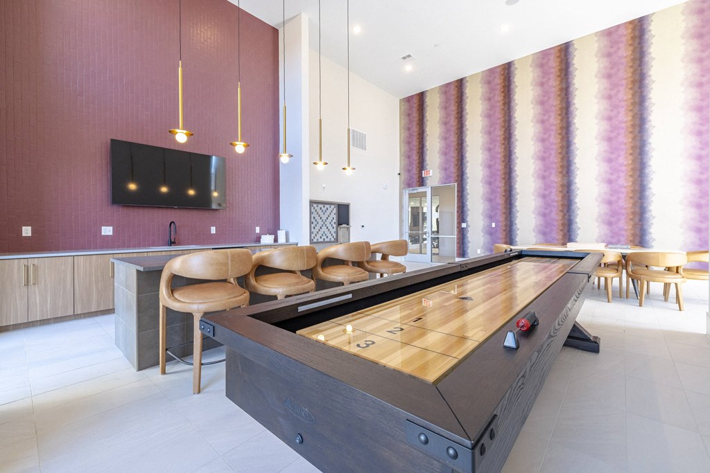 a foosball table in a game room with chairs