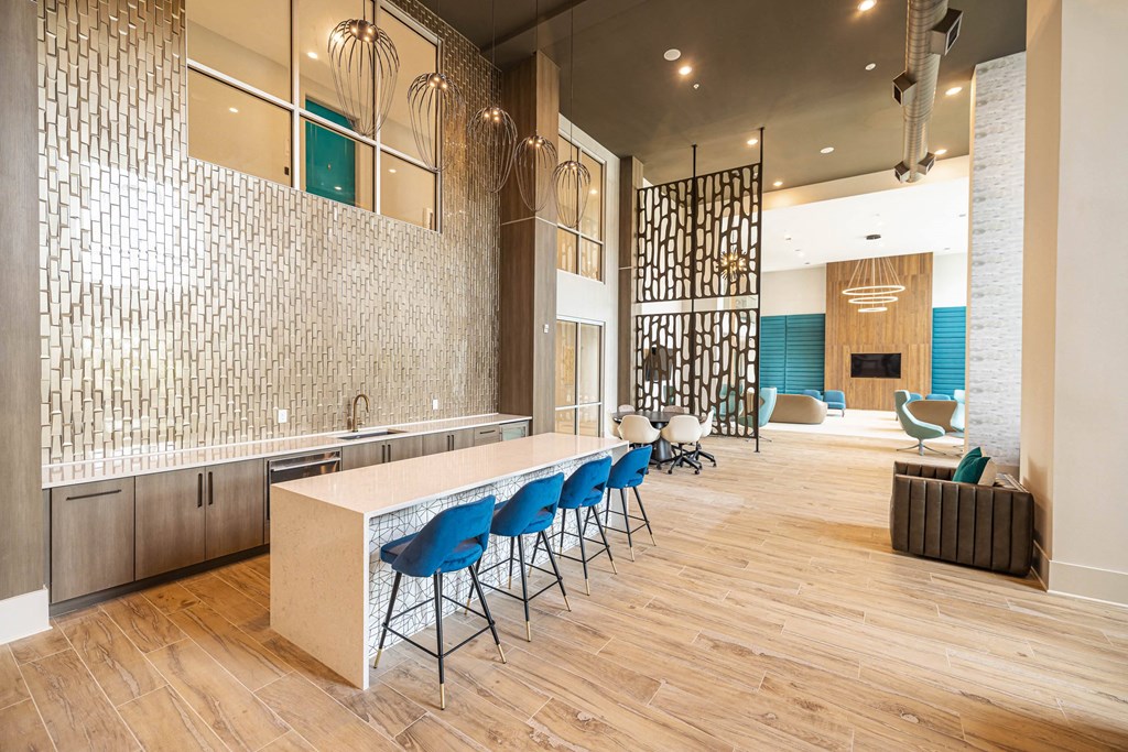 a kitchen with blue chairs and a long white counter
