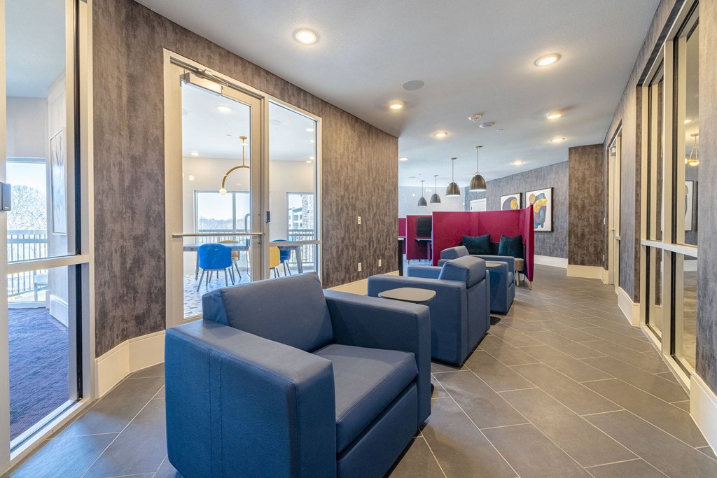 the lobby of a hotel with blue couches and chairs