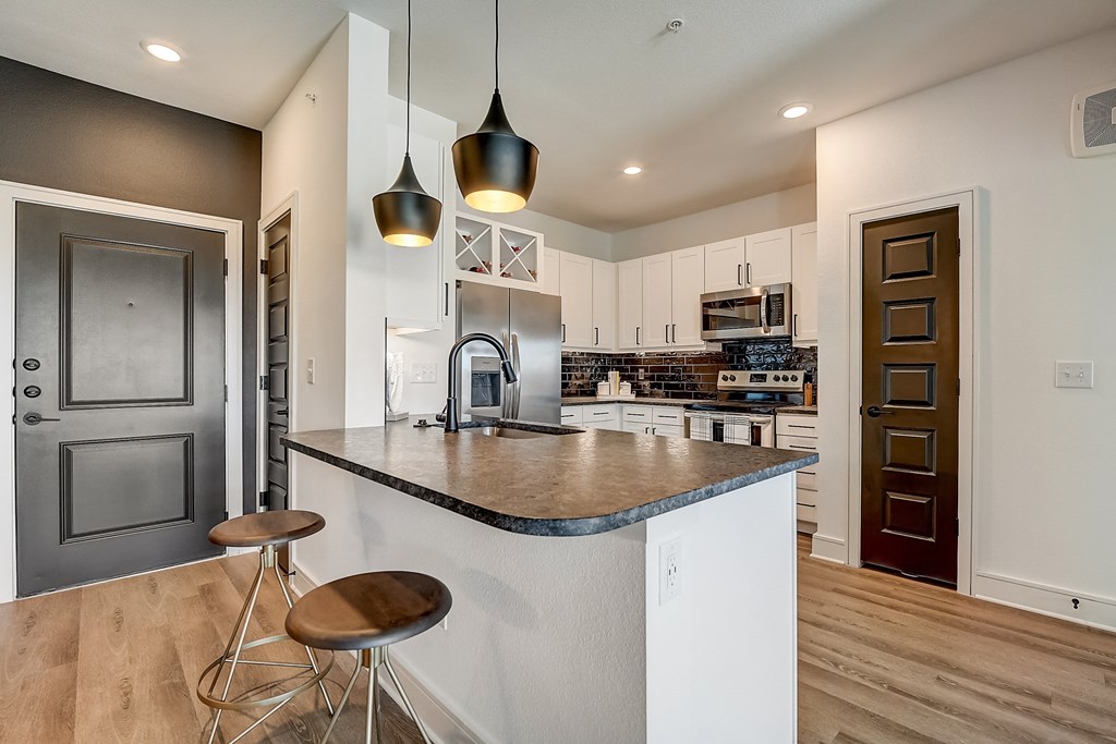 a kitchen with an island and stools in a house