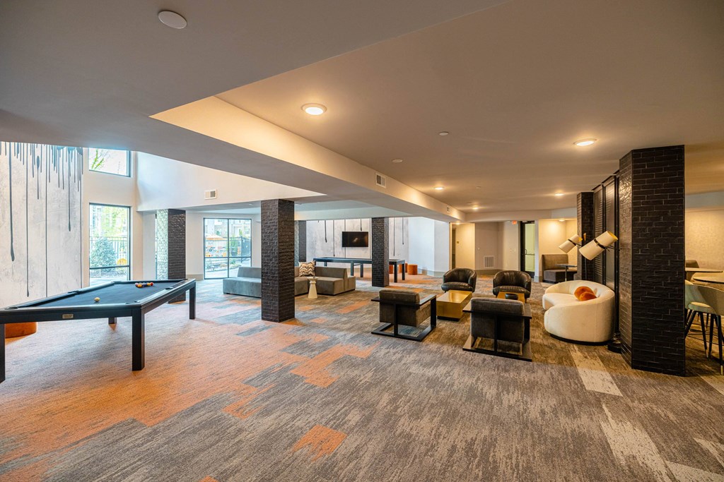 a clubhouse with a pool table and a living room with couches