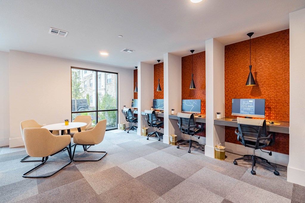 an office space with desks and chairs and a large window
