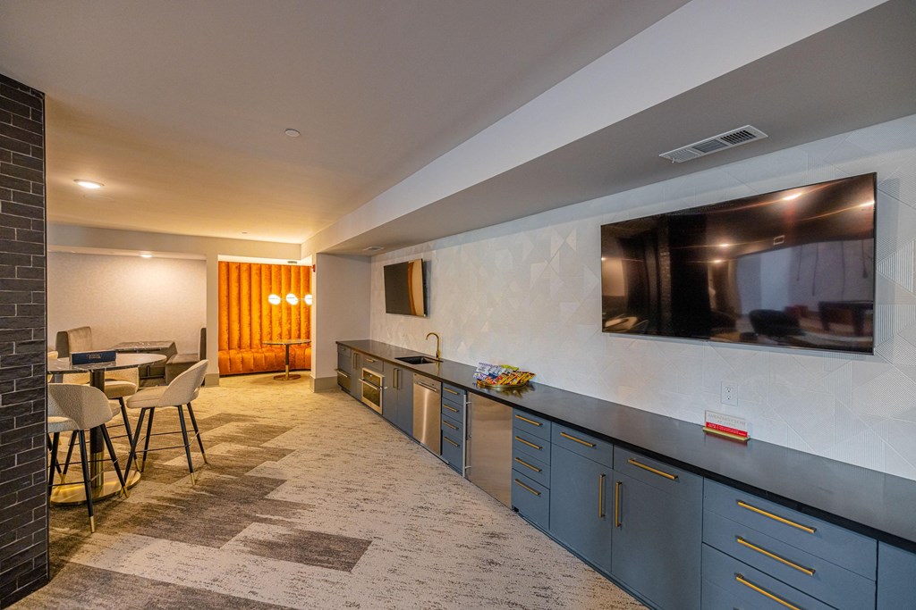 a kitchen with blue cabinets and a tv on the wall