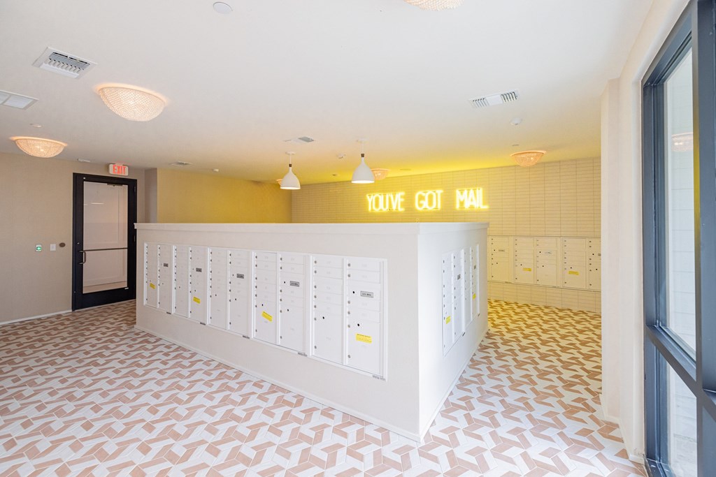 A hallway with a sign that says "YOU'VE GOT MAIL" above a row of mailboxes.