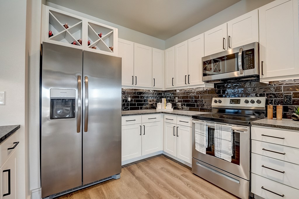 a kitchen with stainless steel appliances and white cabinets