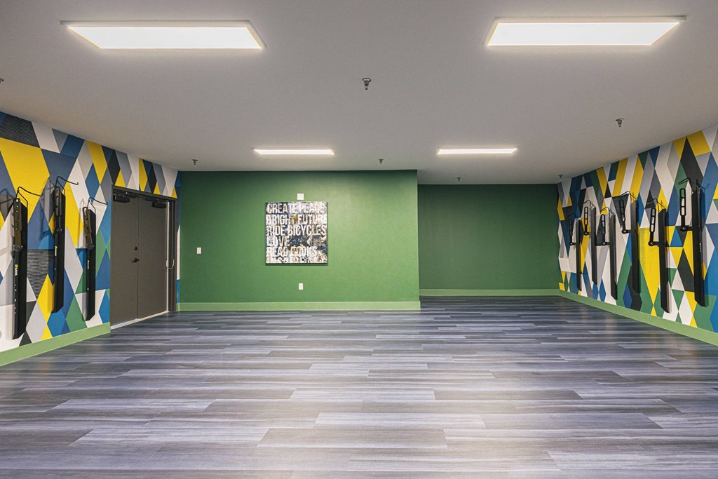 a room with green walls and wooden floors and a painting on the wall