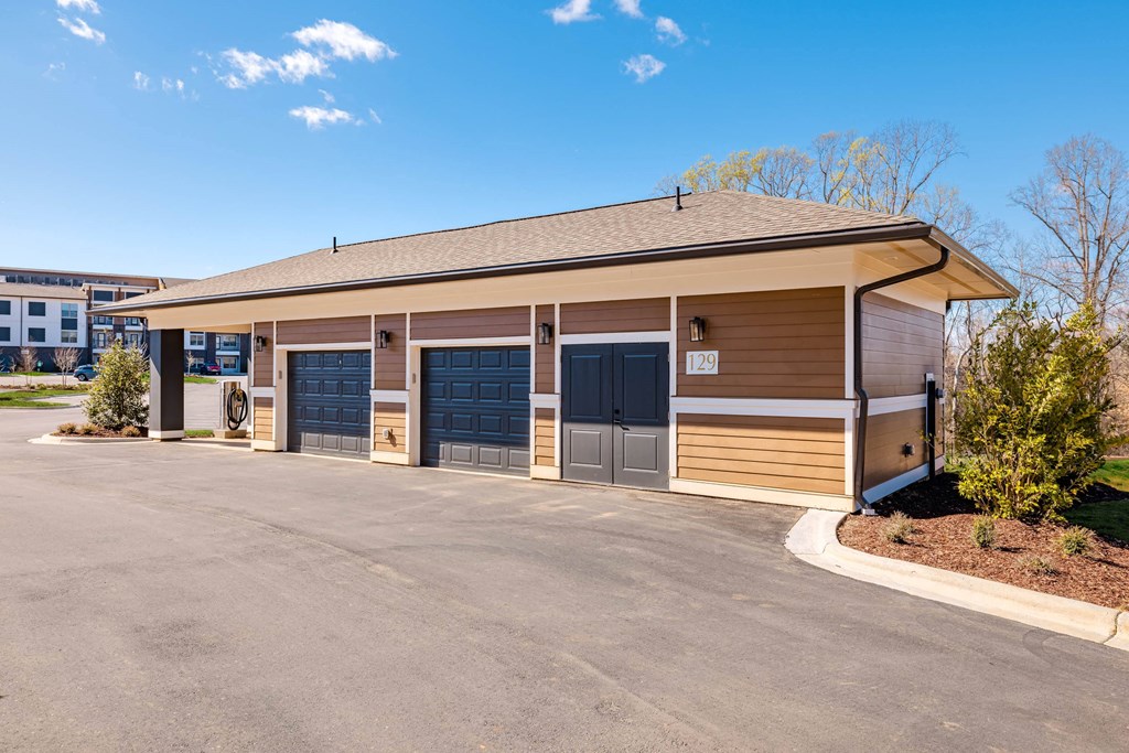 the front of a building with a parking lot and garage doors