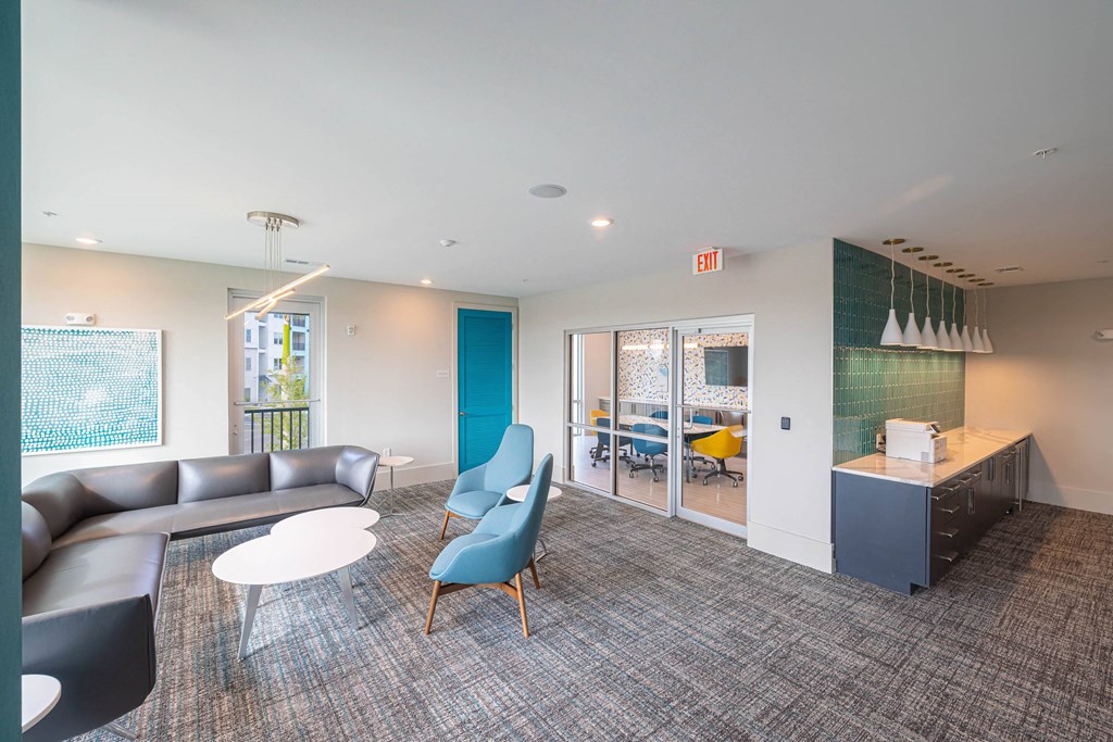 a living room with a couch and chairs and a kitchen