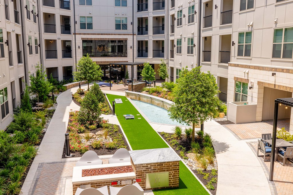 a courtyard with a pool and trees in front of an apartment building