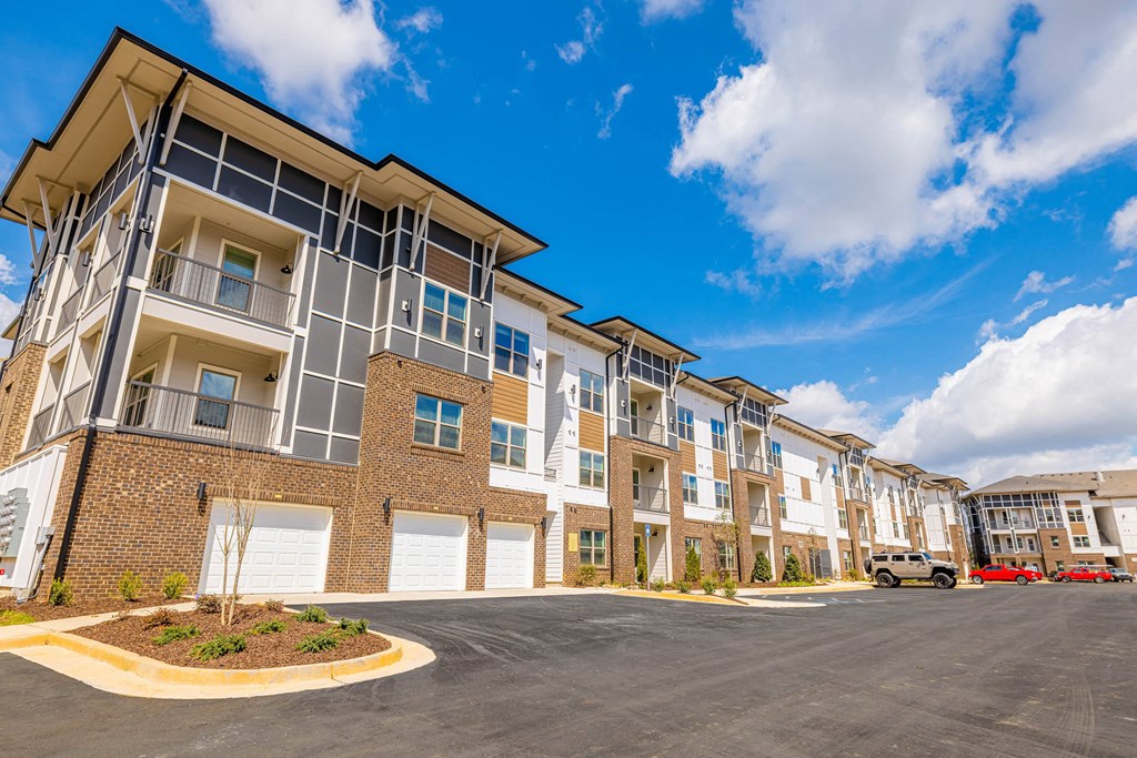 an exterior view of an apartment building with a parking lot