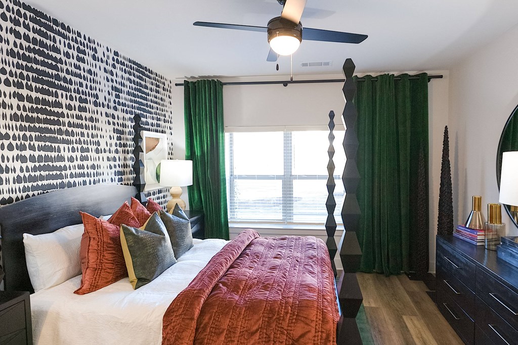 a bedroom with a large bed and green curtains