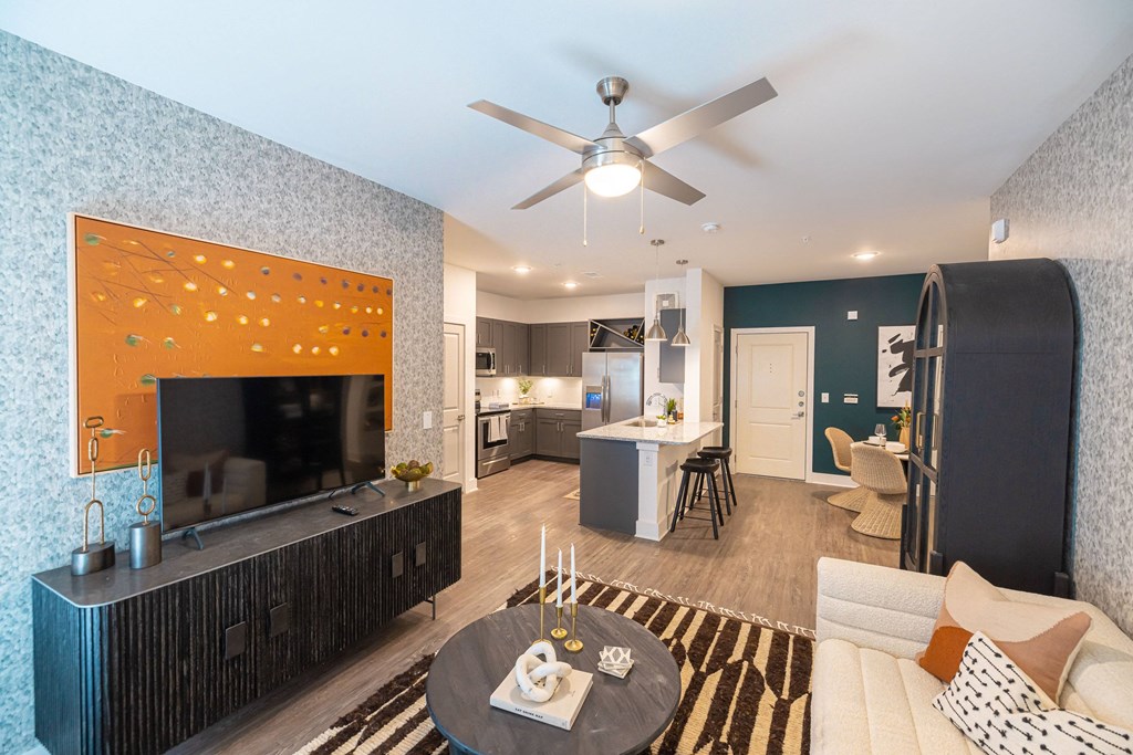 a living room with a ceiling fan and a television